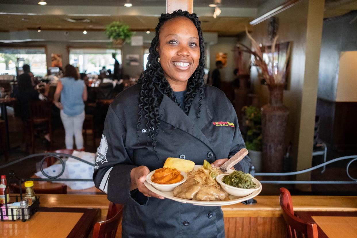 Rocki Adams holds a dish of Kam's Pork Chops, one of the signature dishes at Southern Hands Home Style Cooking.