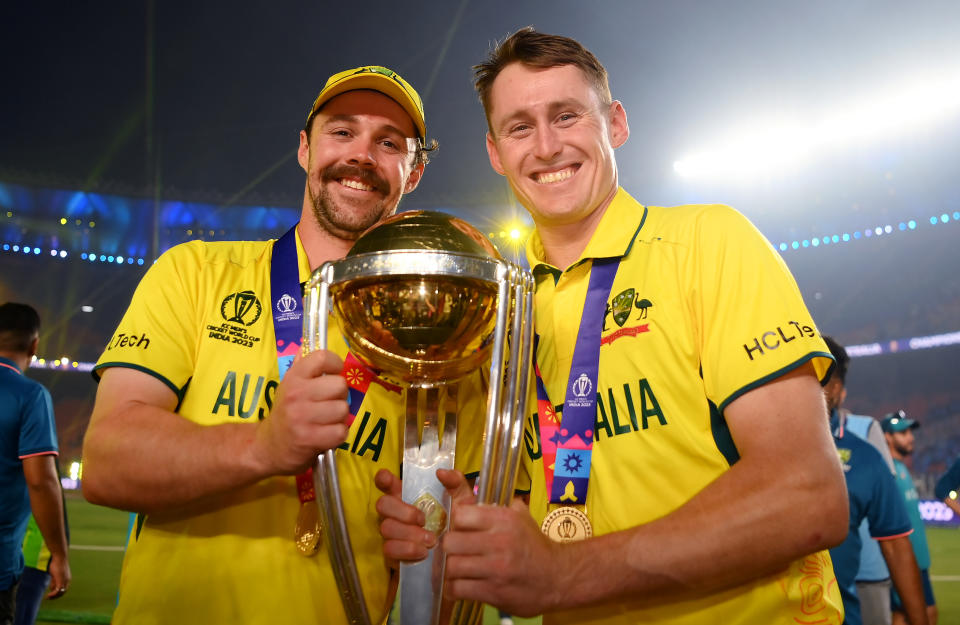 Travis Head and Marnus Labuschagne pose with the World Cup trophy.