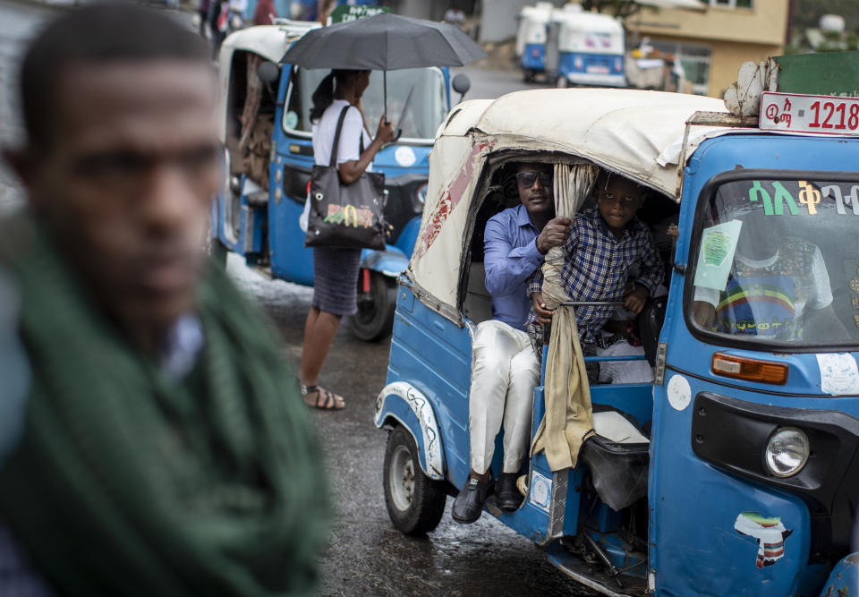 Passengers look out from an auto-rickshaw, known locally as a "bajaj", in Gondar, in the Amhara region of Ethiopia Sunday, May 2, 2021. Ethiopia faces a growing crisis of ethnic nationalism that some fear could tear Africa's second most populous country apart, six months after the government launched a military operation in the Tigray region to capture its fugitive leaders. (AP Photo/Ben Curtis)