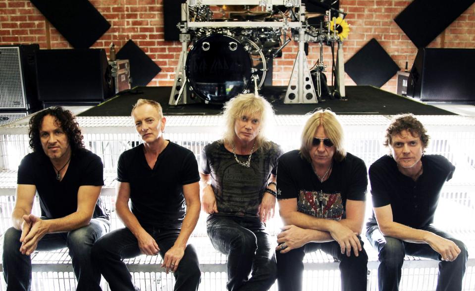 FILE - This May 31, 2012 file photo shows, from left, Vivian Campbell, Phil Collen, Rick Savage, Joe Elliott, and Rick Allen, of musical group Def Leppard in Los Angeles. Kiss and Def Leppard are joining forces for a summer tour. The legendary bands will embark on a U.S. tour June 23 in West Valley City, Utah. (Photo by Matt Sayles/Invision/AP, File)