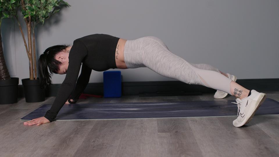 Writer Sam performing X plank on yoga mat in studio