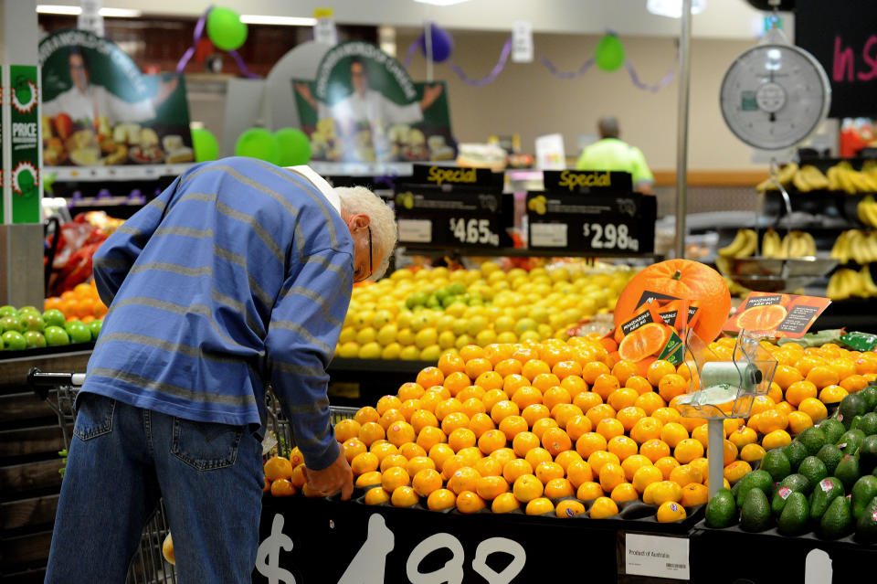 A shopper inspects fruit inside a Woolworths grocery store in Brisbane.