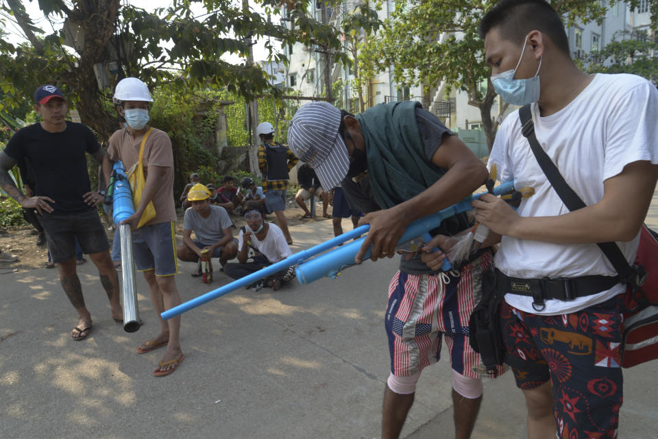 Anti-coup protesters check their homemade air guns in Yangon, Myanmar on Thursday, March 24, 2021. Protesters against last month's military takeover in Myanmar returned to the streets in large numbers Thursday, a day after staging a "silence strike" in which people were urged to stay home and businesses to close for the day. (AP Photo)