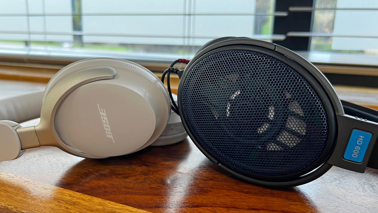  A pair of Sennheiser open-back headphones with the speaker visible through the grille, next to a pair of Bose closed-back headphones. 