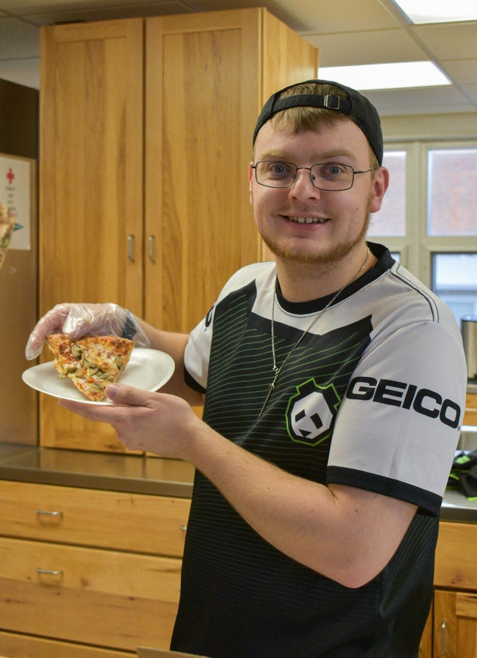 In addition to helping to plan and set up the fundraiser, Alex Herman also volunteered to serve pizza at the party.