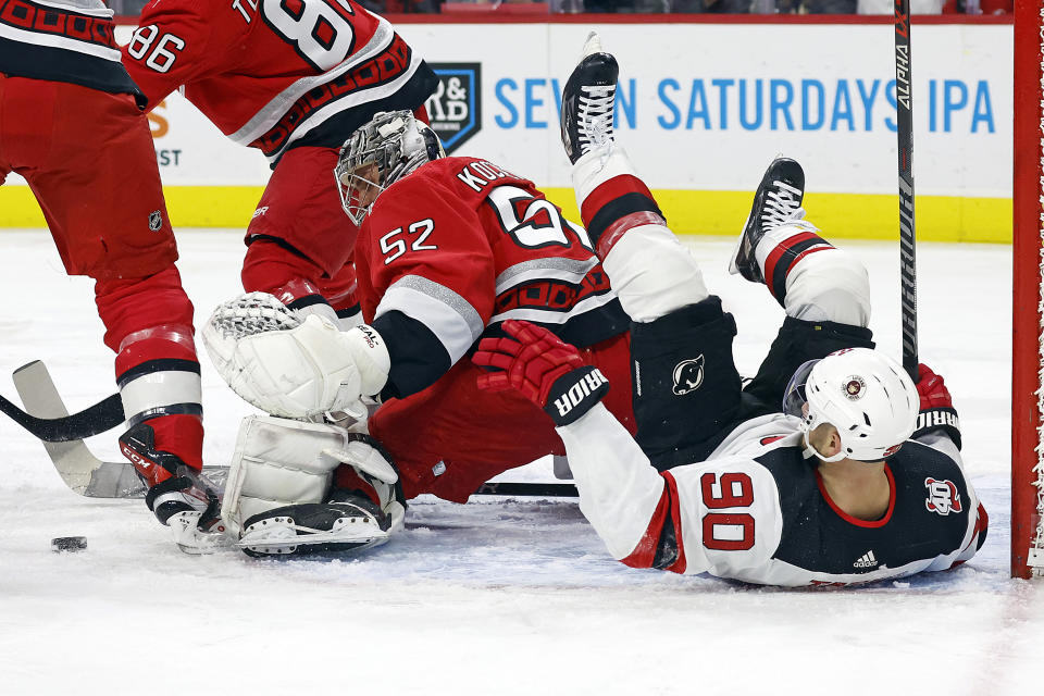 Carolina Hurricanes goaltender Pyotr Kochetkov watches the puck after colliding with New Jersey Devils' Tomas Tatar (90) during the first period of an NHL hockey game in Raleigh, N.C., Tuesday, Dec. 20, 2022. (AP Photo/Karl B DeBlaker)