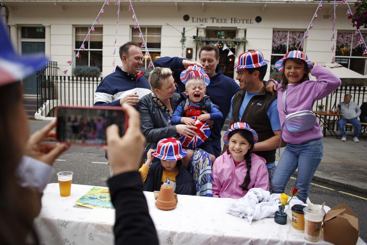 People pose for a photo during a public street party in central London, Sunday, June 5, 2022, on the last of four days of celebrations to mark the Platinum Jubilee. Street parties are set to be held across the country in what is being called The Big Jubilee Lunch.