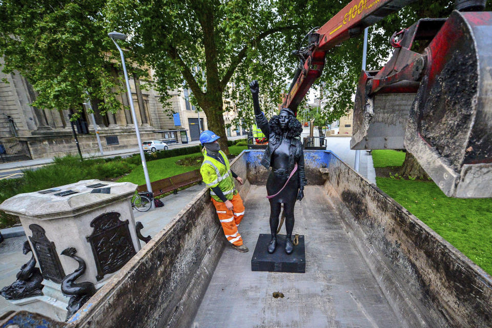 Contractors remove the statue "A Surge of Power (Jen Reid) 2020" by artist Marc Quinn, which had been installed on the site of the fallen statue of the slave trader Edward Colston, in Bristol, England, Thursday, July 16, 2020. The sculpture of protester Jen Reid was installed without the knowledge or consent of Bristol City Council and was removed by the council 24 hours later. (Ben Birchall/PA via AP)