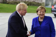 German Chancellor Angela Merkel, right, greets British Prime Minister Boris Johnson during arrivals for a conference on Libya at the chancellery in Berlin, Germany, Sunday, Jan. 19, 2020. German Chancellor Angela Merkel hosts the one-day conference of world powers on Sunday seeking to curb foreign military interference, solidify a cease-fire and help relaunch a political process to stop the chaos in the North African nation. (AP Photo/Jens Meyer)