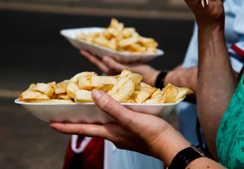 FILE PHOTO: People eat chips whilst walking along the promenade at the British holiday resort of Scarborough