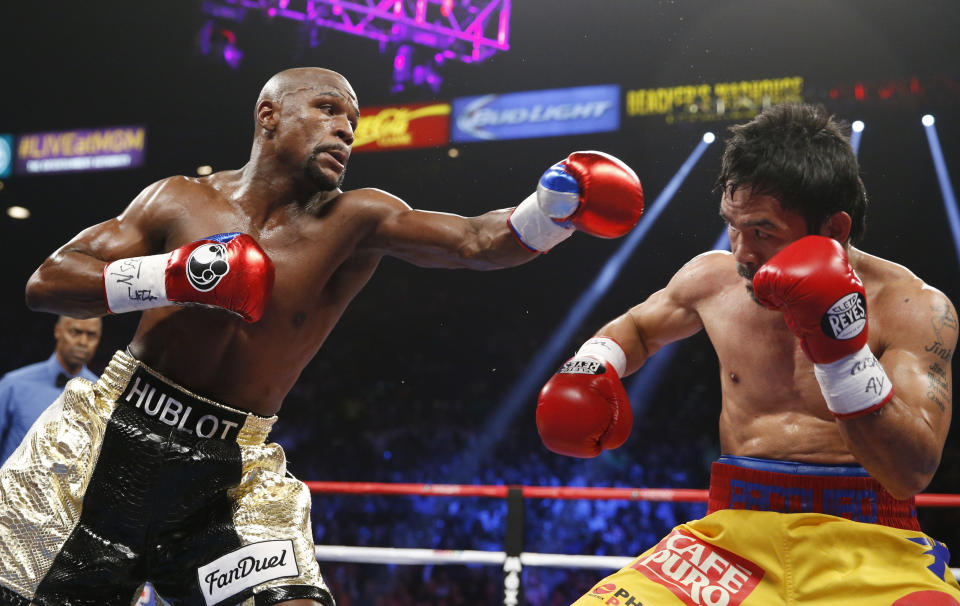 Floyd Mayweather Jr., left, trades blows with Manny Pacquiao, from the Philippines, during their welterweight title fight on Saturday, May 2, 2015 in Las Vegas. (AP Photo/John Locher)