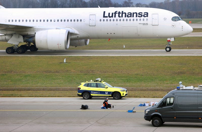 The last of four climate activists sits with his hand glued to the feeder road of a runway at Franz-Josef-Strauss Airport in Munich, Germany, on Thursday, Dec. 8, 2022.