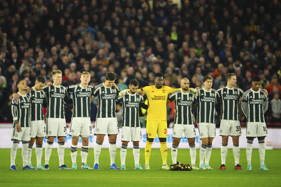 Manchester United players observe a minute of silence in honour of late English soccer legend Bobby Charlton and for the victims of the Israeli-Hamas war before the English Premier League soccer match between Sheffield United and Manchester United at Bramall Lane in Sheffield, England, Saturday, Oct. 21, 2023. (AP Photo/Jon Super)