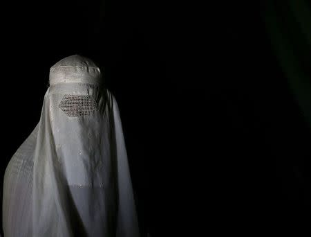 An Afghan refugee woman, clad in a burqa and returning from Pakistan, watches a short video clip about mines at a mines and explosives awareness program at a United Nations High Commissioner for Refugees (UNHCR) registration centre in Kabul, Afghanistan September 2, 2015. REUTERS/Ahmad Masood