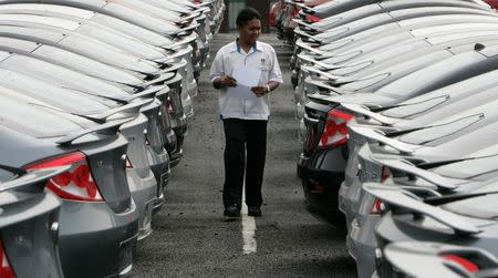 A worker checks new Proton cars at a yard near Kuala Lumpur January 12, 2009. REUTERS/Zainal Abd Halim/File Photo