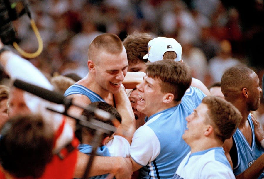 North Carolina’s Eric Montross, left, gets mobbed by cheerleaders and fans after the Tar Heel beat Michigan 77-71 to win the national championship Monday in New Orleans, LA., April 5, 1993. (AP Photo/Ed Reinke)