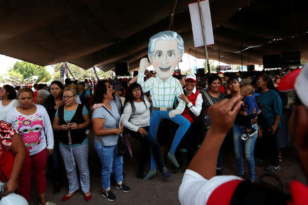 Supporters of Alfredo del Mazo of Institutional Revolutionary Party (PRI), candidate for governor of the State of Mexico, pose for a photographe with his image during his electoral campaign in Ecatepec in State of Mexico, Mexico May 18, 2017. Picture taken on May 18, 2017. REUTERS/Carlos Jasso