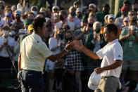 Hideki Matsuyama, of Japan, shakes hands with Xander Schauffele on the 18th hole after winning the Masters golf tournament on Sunday, April 11, 2021, in Augusta, Ga. (AP Photo/Gregory Bull)
