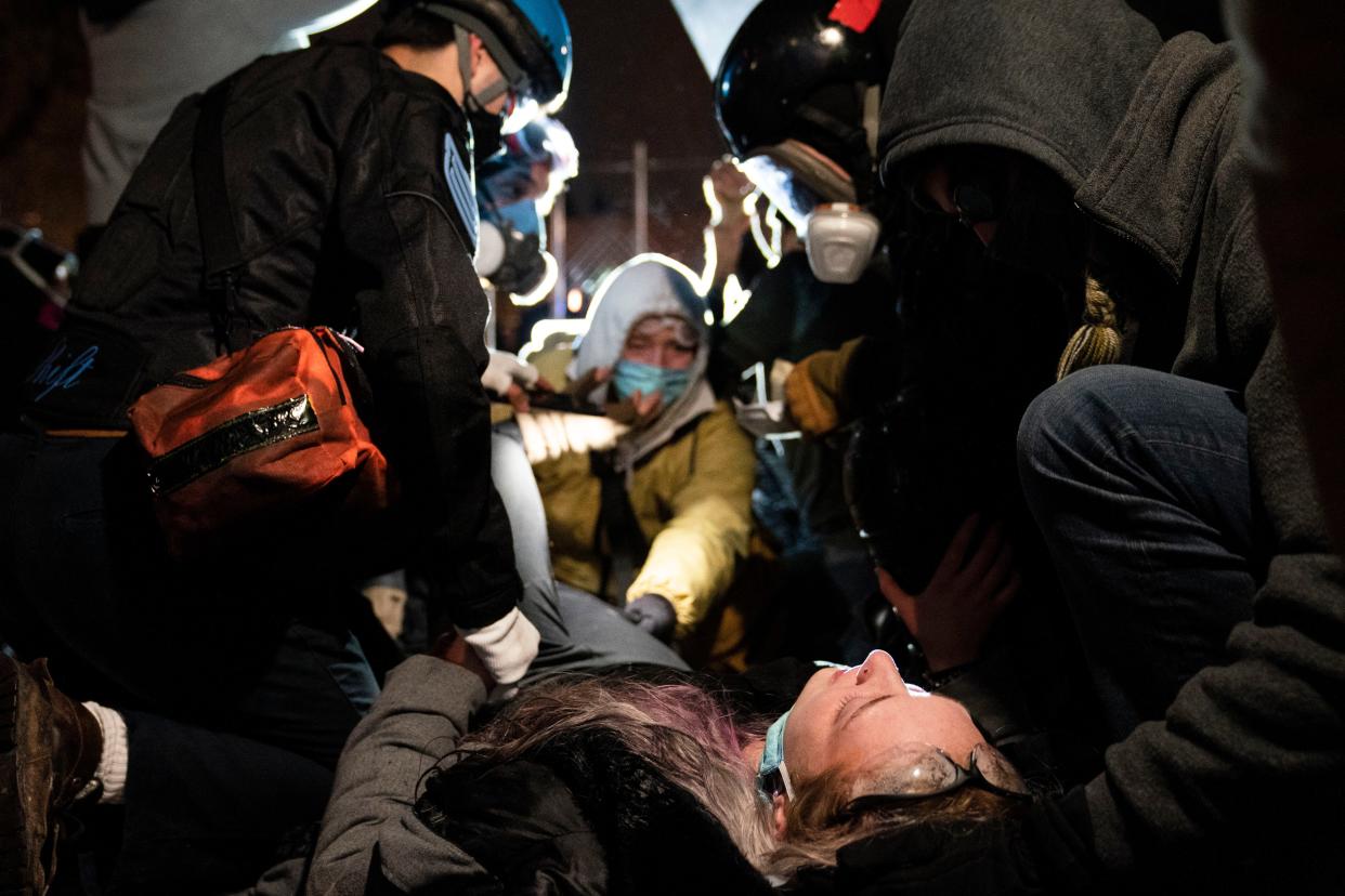 An injured demonstrator is assisted by medics during a protest over Sunday's shooting death of Daunte Wright outside the Brooklyn Center Police Department on Wednesday, April 14, 2021, in Brooklyn Center, Minn.