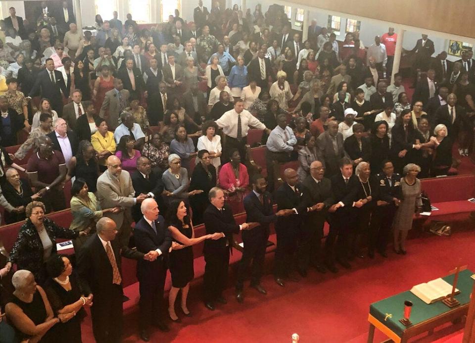 Presidential candidate and former Vice President Joe Biden, left front, joins the congregation of 16th Street Baptist Church in Birmingham, Alabama, as they sing "We Shall Overcome" at Sunday worship on Sept. 15, 2019. Biden was the keynote speaker as the congregation commemorated the 56th anniversary of the Ku Klux Klan bombing that killed four black girls in the congregation during the height of the civil rights movement. Biden is on the front pew along with Alabama Sen. Doug Jones, who as a federal prosecutor decades after the bombings prosecuted two of the responsible Klansmen, and Birmingham Mayor Randall Woodfin.