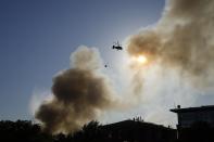 A Russian Emergency Situations Ministry helicopter dumps water on fire at a warehouse in Moscow, Russia, Saturday, June 19, 2021. A large fire broke out at a fireworks depot in the center of Moscow. The fire is raging at the area of 500 square meters, Russia emergency services said in the statement. (AP Photo/Pavel Golovkin)