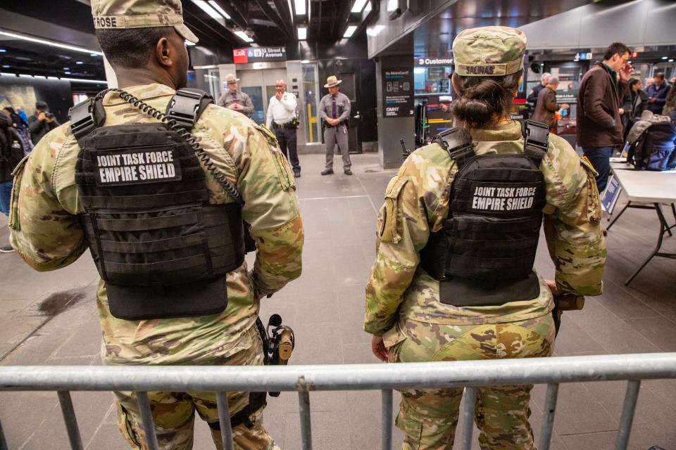 Members of the Armed Forces, including the National Guard, patrol last week in the New York City the subway system as police officers check commuters' bags. A man was shot and critically wounded Thursday with his own gun during a fight a week Gov. Kathy Hochul sent the National Guard to city's subway system to help police search passengers' bags for weapons.