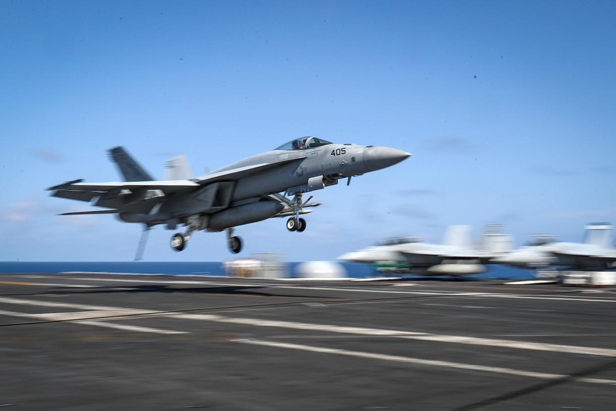 This handout picture released by the US Navy on May 20, 2019 shows a F/A-18E Super Hornet from the Fist of the Fleet of Strike Fighter Squadron (VFA) 25 landing on the flight deck of the Nimitz-class aircraft carrier USS Abraham Lincoln (CVN 72) at the Persian Gulf.