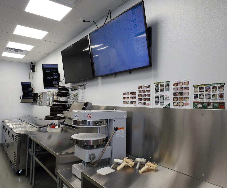 Redesigned production lines are a part of the new Papa John's Pizza at 439 Cambridge Road. Big screens show orders and track delivery drivers.