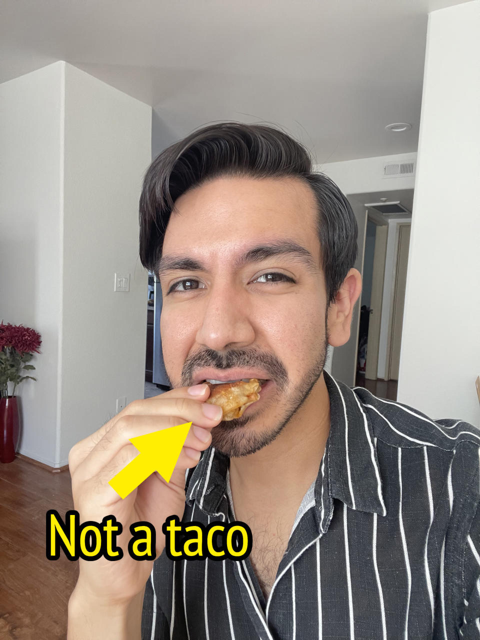 The author eating an empanada with the words "not a taco"