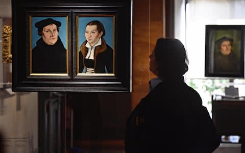 A visitor looks at the painting 'Portrait of Martin Luther and Katharina Von Bora' by Lucas Cranach the Elder, on display as part of the exhibition " I volti della Riforma. Lutero e Cranach nelle collezioni medicee '' at the Uffizi Gallery in Florence, Italy, Monday, Oct. 30, 2017. - Credit: Ansa/AP