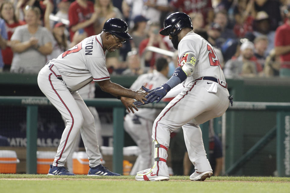 Atlanta Braves' Marcell Ozuna, right, celebrates with third base coach Ron Washington after hitting two-run home run during the third inning of a baseball game against the Washington Nationals, Monday, June 13, 2022, in Washington. (AP Photo/Luis M. Alvarez)