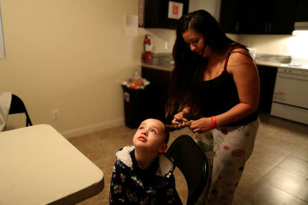 Yuritzy Quinones, 29, (R) gets her daughter Anaiah Garcia, 4, ready for school in the kitchen of the family shelter in which they are staying in Los Angeles, California, U.S. March 22, 2018. Picture taken March 21, 2018. REUTERS/Lucy Nicholson