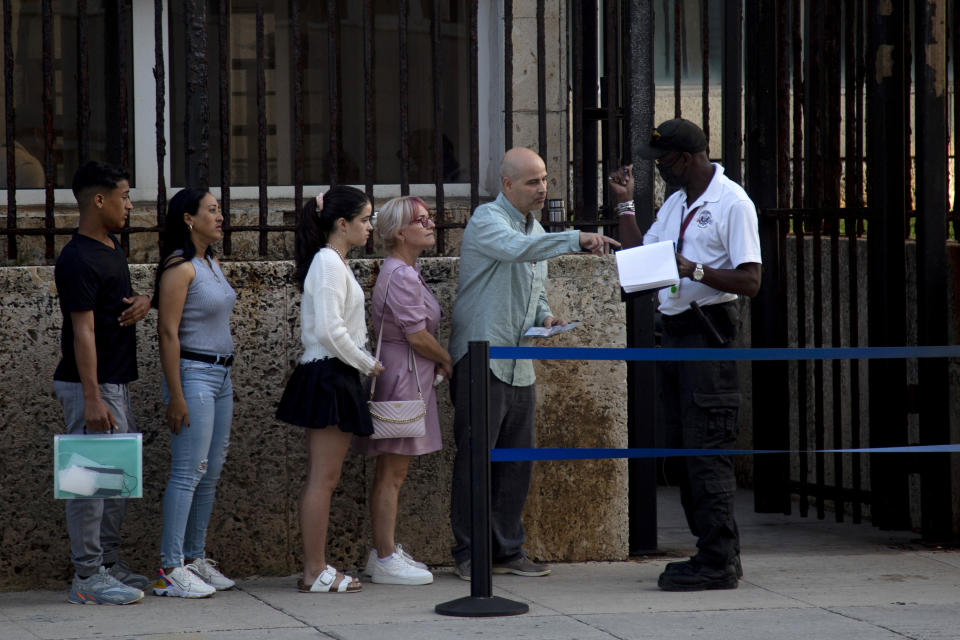 People stand in line outside the U.S. embassy on the day of its reopening for visa and consular services in Havana, Cuba, Wednesday, Jan. 4, 2023. (AP Photo/Ismael Francisco)