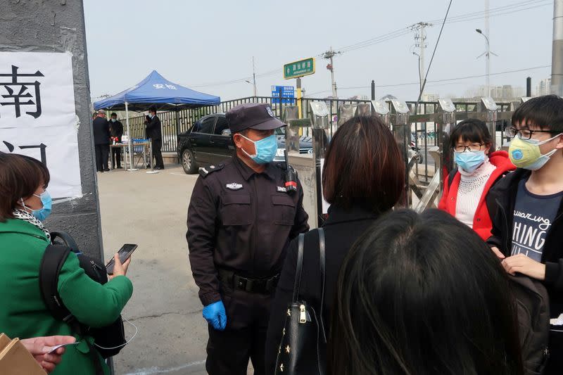 FILE PHOTO: People wait at an entrance to a labour arbitration office in Beijing