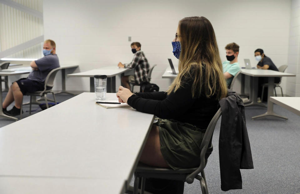 Students sitting one per row on each side of the room and wearing face masks, listen to instructor Robert Gynn, during a speech class at College of Lake County in Grayslake, Ill., Thursday, July 8, 2020. Six students were present, with a room capacity for nine. (Abel Uribe/Chicago Tribune via AP)