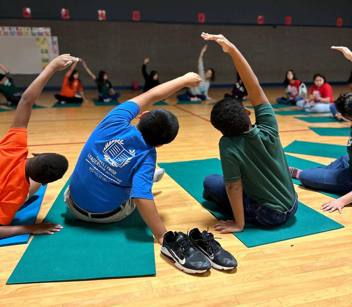 Fort Worth ISD students hold a pose during a yoga class taught by Nanda Yoga.