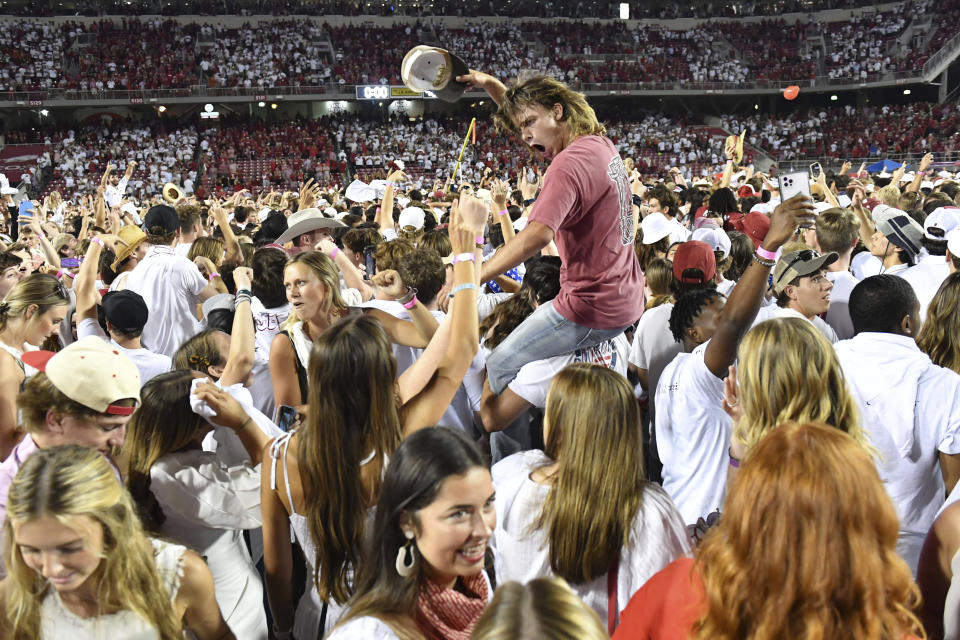 Arkansas fans rush the field to celebrate Arkansas' win over Texas in an NCAA college football game Saturday, Sept. 11, 2021, in Fayetteville, Ark. (AP Photo/Michael Woods)