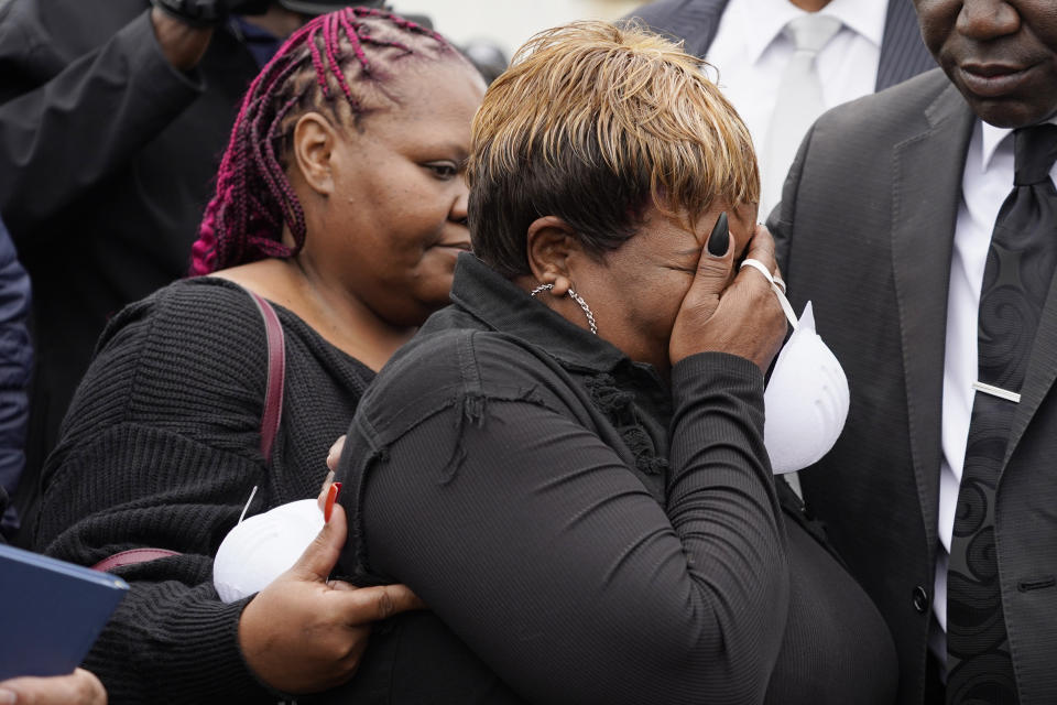 Bettersten Wade, mother of Dexter Wade, a 37-year-old man who died after being hit by a Jackson, Miss., police SUV driven by an off-duty officer, is comforted by her daughter, Latonya Moore, left, while watching her son's body transferred to a mortuary transport, after being exhumed from a pauper's cemetery near the Hinds County Penal Farm in Raymond, Monday, Nov. 13, 2023. Civil rights attorney Ben Crump said Monday he is asking the U.S. Justice Department to investigate why authorities waited several months to notify the family of his death. (AP Photo/Rogelio V. Solis)