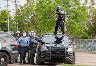 Police officer aims gun before firing at people at the Minneapolis Police Department's Third Precinct station to protest the death of George Floyd, in Minneapolis, Minnesota