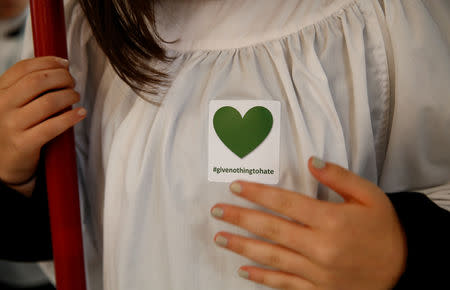 A choir girl wears a sticker as a show of solidarity with the victims of the mosque shootings in Christchurch, New Zealand, March 17, 2019. REUTERS/Edgar Su