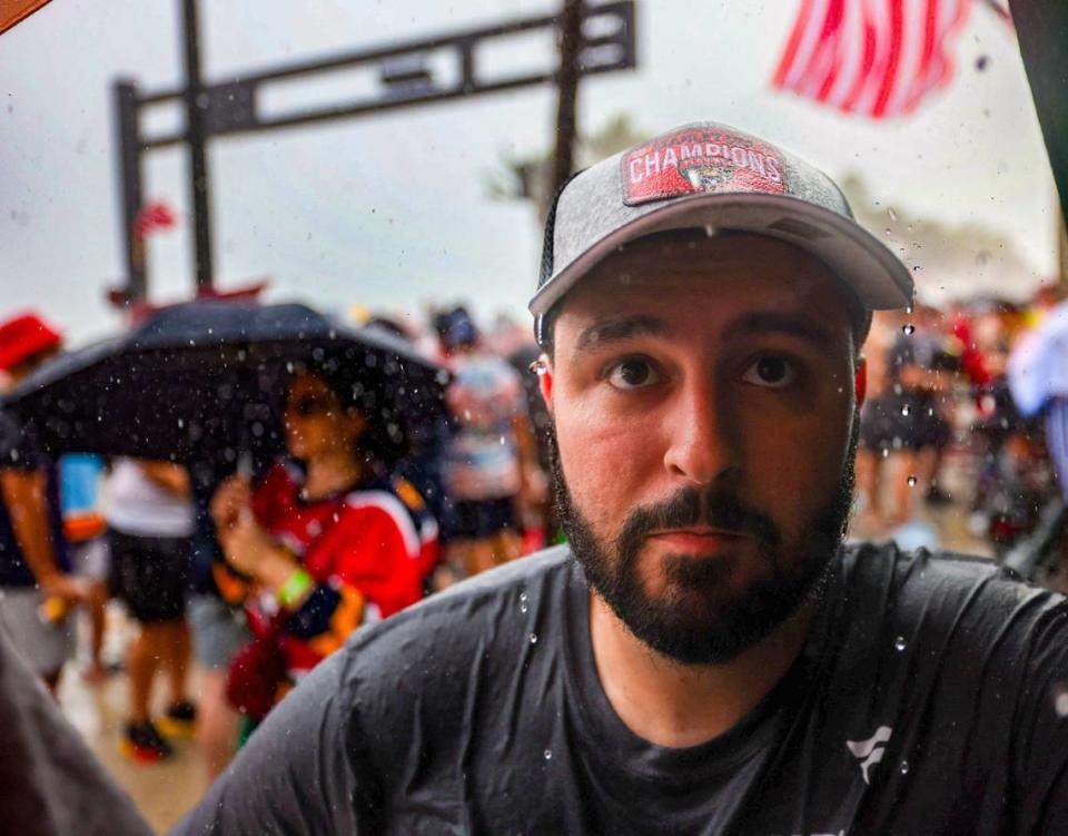 Raindrops fall from the hat of Florida Panthers fan Brian Vazquez as he takes cover under a balcony in the Elbo Room as a storm begins to gather on a Fort Lauderdale beach prior to the Florida Panthers' Stanley Cup Victory Parade on Fort Lauderdale Beach on Tuesday, June 30, 2024, in Fort Lauderdale. 