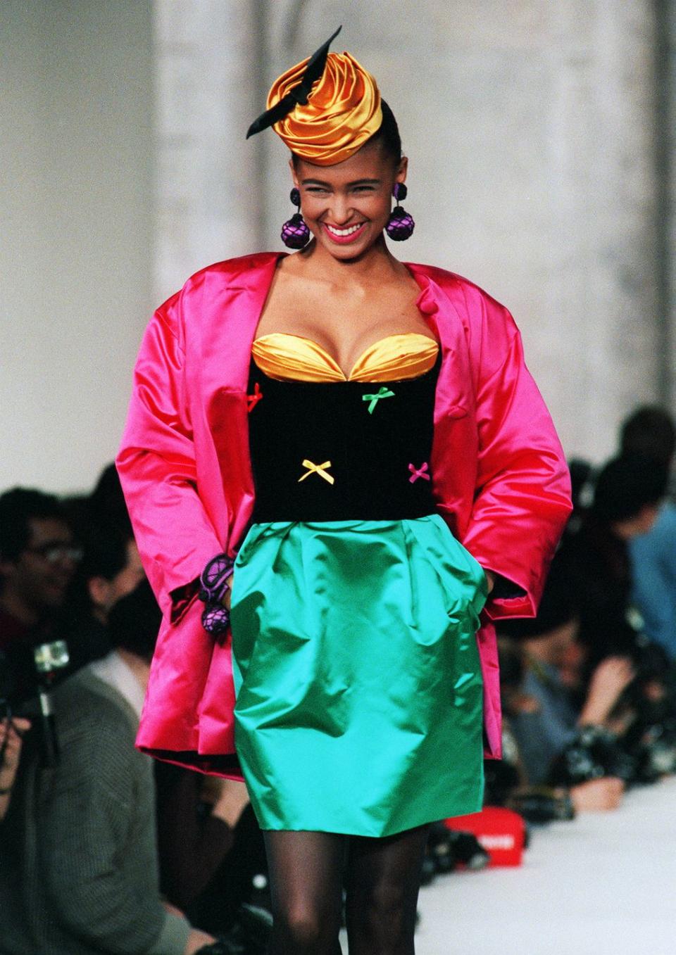 <p>What is '80s fashion if not extreme neon tones? This look on the Dior Fall/Winter runway embraced every color possible, with an orange corset, an emerald green skirt, and a hot pink satin jacket.</p>