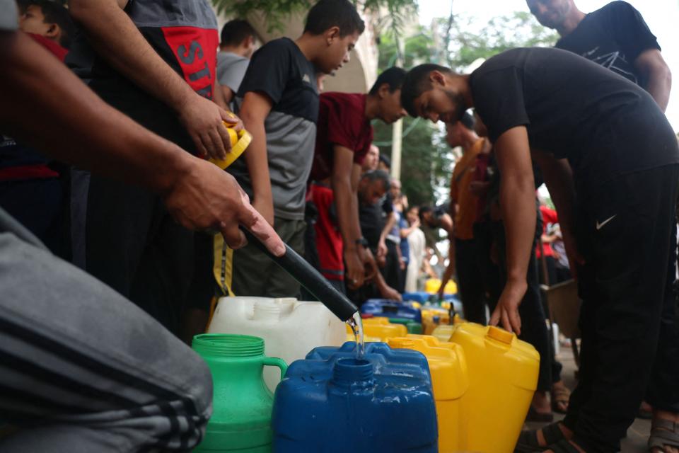Palestinians fill plastic jerrycans at a portable water filling point, in Rafah in the southern Gaza Strip on October 28, 2023, amid the ongoing battles between Israel and the Palestinian group Hamas. Thousands of civilians, both Palestinians and Israelis, have died since October 7, 2023, after Palestinian Hamas militants based in the Gaza Strip entered southern Israel in an unprecedented attack triggering a war declared by Israel on Hamas with retaliatory bombings on Gaza.