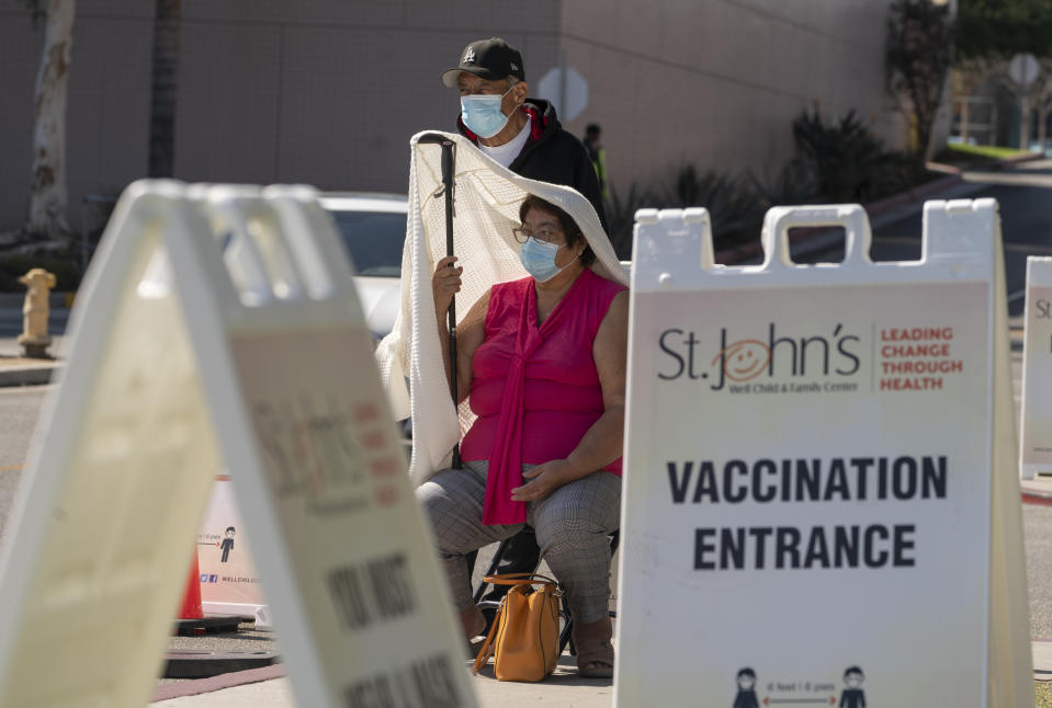 Jose Rosas and his wife, Sara, who live in the 90060 zip code, wait in line to be screened for high temperature before being vaccinated at the St. John's Well Child and Family Center just-opened COVID-19 vaccination site at the East Los Angeles Civic Center in Los Angeles, Thursday, March 4, 2021. California will begin setting aside 40% of all vaccine doses for the state's most vulnerable neighborhoods in an effort to inoculate people most at risk from the coronavirus more quickly. The doses will be spread among 400 ZIP codes where there are about 8 million people eligible for shots. Advocates for health and racial justice cheered the move given the disproportionate number of cases and deaths among Latinos. (AP Photo/Damian Dovarganes)