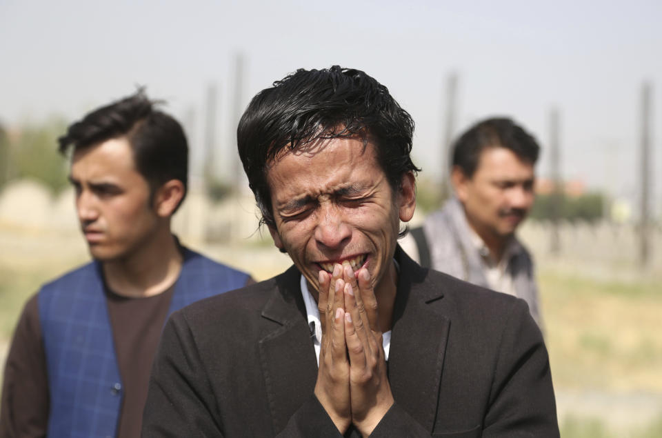 Relatives mourn a victim in western Kabul, Afghanistan, Thursday, Aug. 16, 2018, after Wednesday's deadly suicide bombing that targeted a training class in a private building in the Shiite neighborhood of Dasht-i Barcha, The Afghan authorities have revised the death toll from the previous day's horrific suicide bombing in a Shite area of Kabul to 34 killed. (AP Photo/Rahmat Gul)