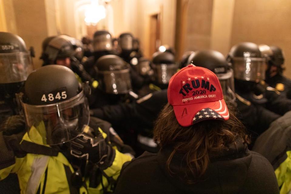 WASHINGTON D.C., USA - JANUARY 6: A US President Donald Trumps supporter faces off security forces after breaching security and entering the Capitol building in Washington D.C., United States on January 06, 2021. Pro-Trump rioters stormed the US Capitol as lawmakers were set to sign off Wednesday on President-elect Joe Biden's electoral victory in what was supposed to be a routine process headed to Inauguration Day. (Photo by Mostafa Bassim/Anadolu Agency via Getty Images)