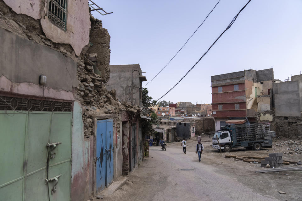 People walk past buildings which were affected by the 2023 earthquake, in the town of Amizmiz, outside Marrakech, Morocco, Wednesday, Sept. 4, 2024. (AP Photo/Mosa'ab Elshamy)