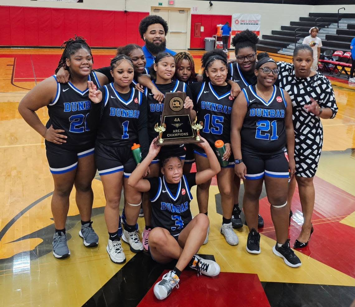 The Fort Worth Dunbar girls basketball team poses with the trophy after defeating Van Alstyne 44-40 in a Class 4A area-round game on Thursday, February 15, 2024 at MacArthur High School in Irving, Texas.