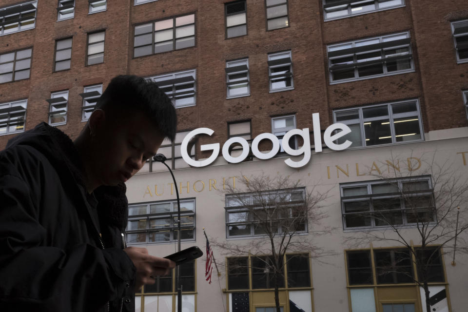 FILE - In this Dec. 17, 2018, file photo a man using a mobile phone walks past Google offices in New York. Australia’s laws forcing Google and Facebook to pay for news are ready to take effect, though the laws' architect said it will take time for the digital giants to strike media deals. The Parliament on Thursday, Feb . 25, 2021, passed amendments to the so-called News Media Bargaining Code agreed between Treasurer Josh Frydenberg and Facebook chief executive Mark Zuckerberg on Tuesday. (AP Photo/Mark Lennihan, File)