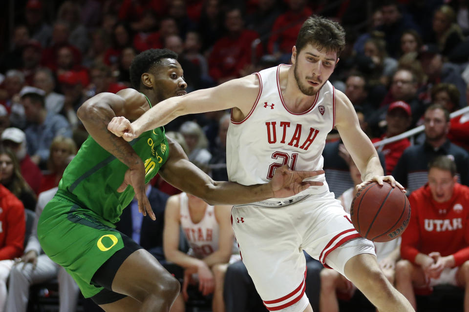 Utah forward Riley Battin (21) drives around Oregon forward Shakur Juiston (10) in the second half during an NCAA college basketball game Saturday, Jan. 4, 2020, in Salt Lake City. (AP Photo/Rick Bowmer)